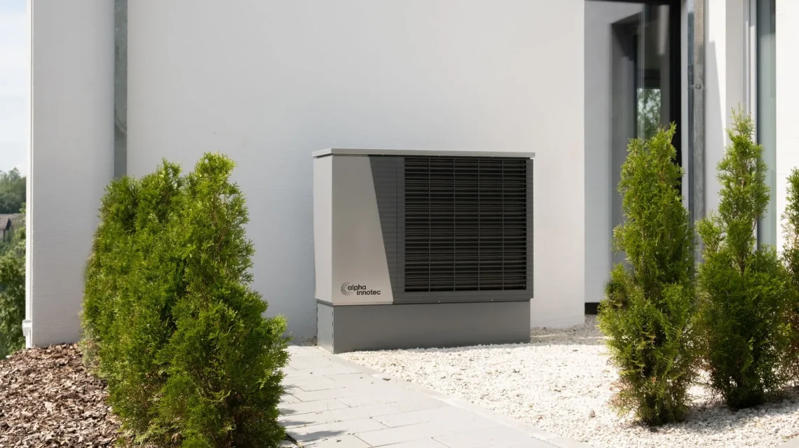 Unité extérieure d'une pompe à chaleur air-eau installée contre la façade d'une maison